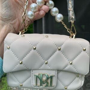 beige purse with pearl handle and brand new with tags great condition